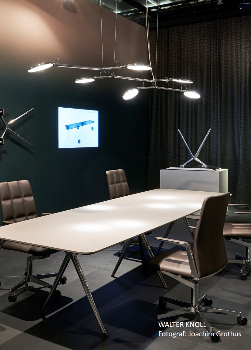 Linearly aligned, branched polished aluminium pendant luminaire with 6 flat round luminaire heads, AVVENI Pendant 6, above the conference table and chairs at the Walter Knoll stand at Orgatec.