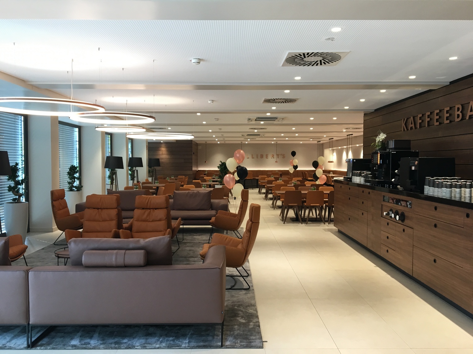 CIRCOLO MINI Ringleuchten im Speisesaal des Krüger Hotels in Bergisch Gladbach Hotel Speisesaal mit Lounge und Kaffeebar des Hotels Krüger in Bergisch Gladbach mit CIRCOLO Mini Ringleuchten über dem Loungebereich.