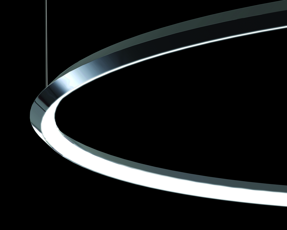 Pointed outer edge - twisted ring profile Detail of a GIRATA HORIZONTAL ring light on a black background. A ring-shaped aluminium profile, polished aluminium, profile bent inwards by 45°, resulting in a tapered outer edge, illuminated inside the ring with an opal diffuser inserted.