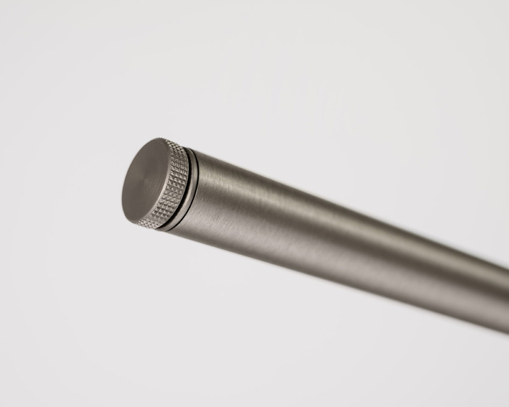 Adjustment of the horizontal luminaire alignment using a knurled screw Silver knurled screw at the end of a silver metal tube.