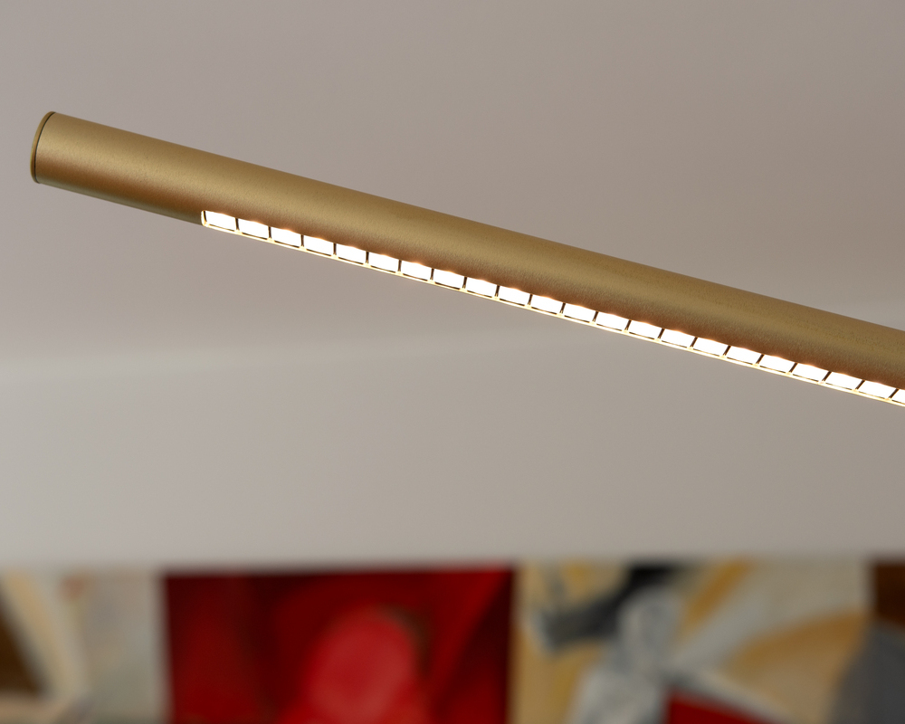 PALITO Linsentechnik Detail der Stehleuchte PALITO zeigt oberen Bereich der zylindrischen Leuchte, mit gebogenem nach unten leuchtenden Bereich. Leuchtenfarbe Champagner Gold, Lichtbereich besteht aus aneinandergereihten viereckigen Linsen.