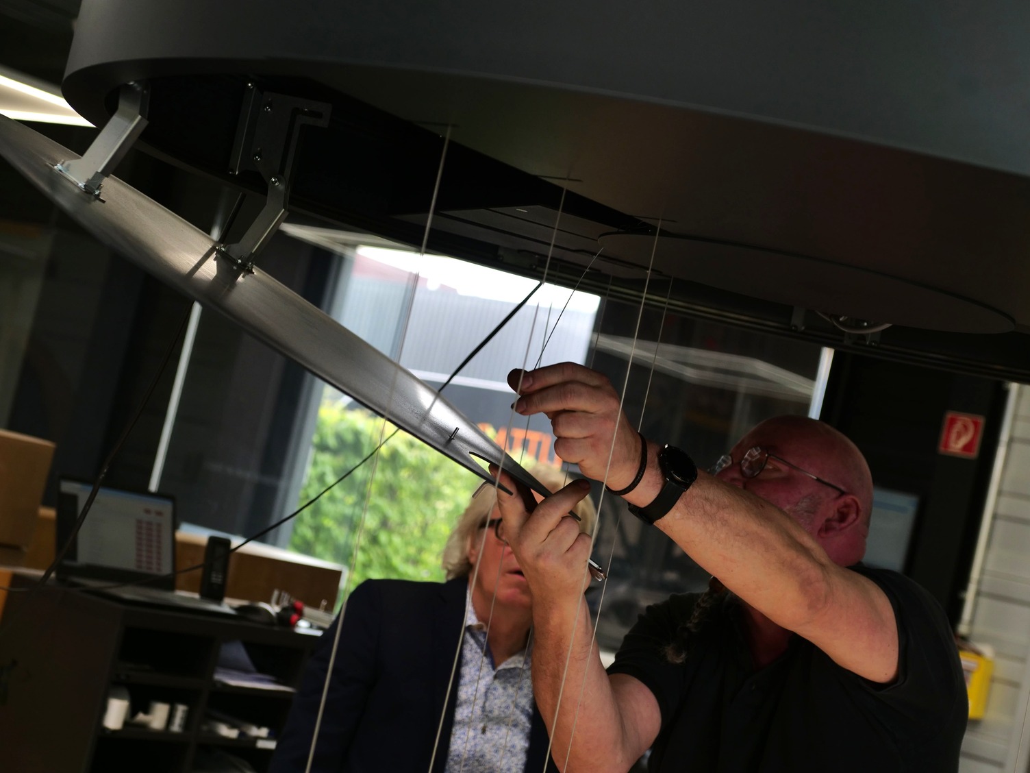 SATTLER PURE MOTION – Assembly of moving rings in the manufactory Technicians installing the kinetic ring luminaire PURE MOTION at the SATTLER manufactory