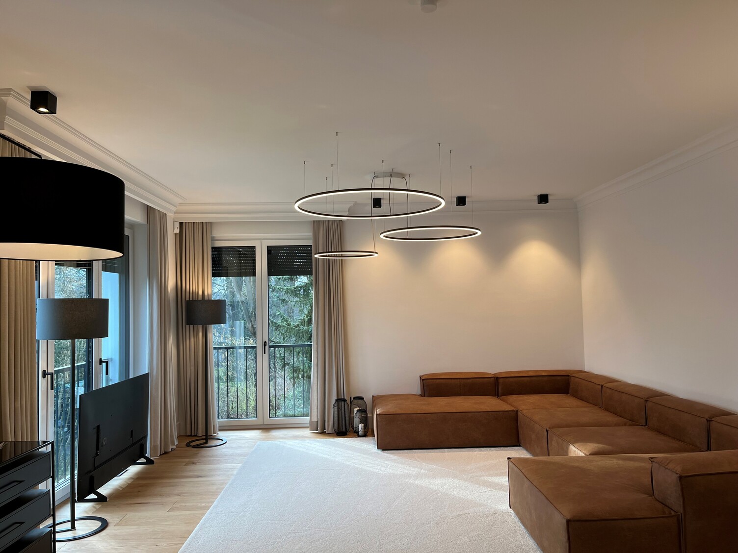 Three SLIM DIRECT Ring Lights in Living Room – Modern Private Home Three filigree SLIM DIRECT LED ring luminaires by SATTLER in a private living room, providing direct and harmonious architectural lighting.