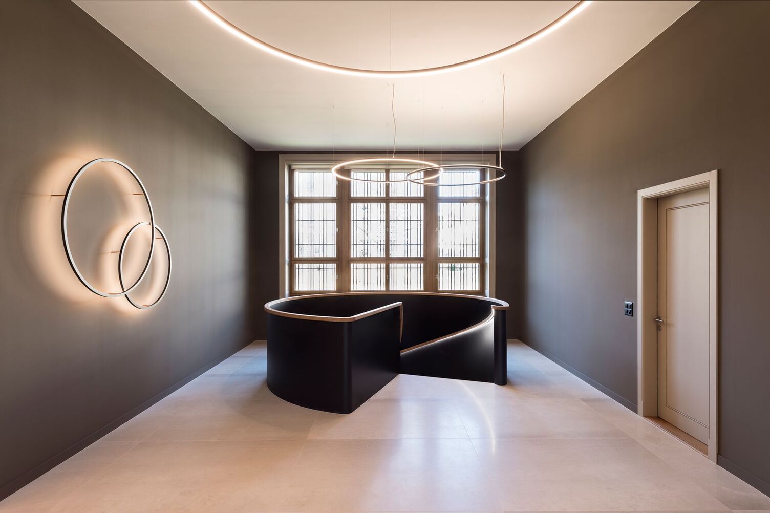 Treppenabgang mit Ringleuchten SLIM In einem historischen Gebäude einer Bank wurden mittels Slim Wall Leuchten in verschiedenen Durchmessern Akzentuierungen geschaffen, sowie die Deckenhöhe mittels indirekt leuchtenden SLIM aufgeweitet. Für eine direkte Beleuchtung sorgt die SLIM direkt um die Grundbeleuchtung des Flurbereiches auszuleuchten.