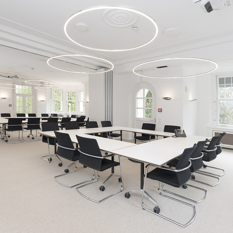 Lohmann & Rauscher Academy – SLIM Ring luminaires for optimal seminar room lighting Bright seminar room at Lohmann & Rauscher Academy with SLIM Ring luminaires by SATTLER. Flexible table arrangement for training and workshops.