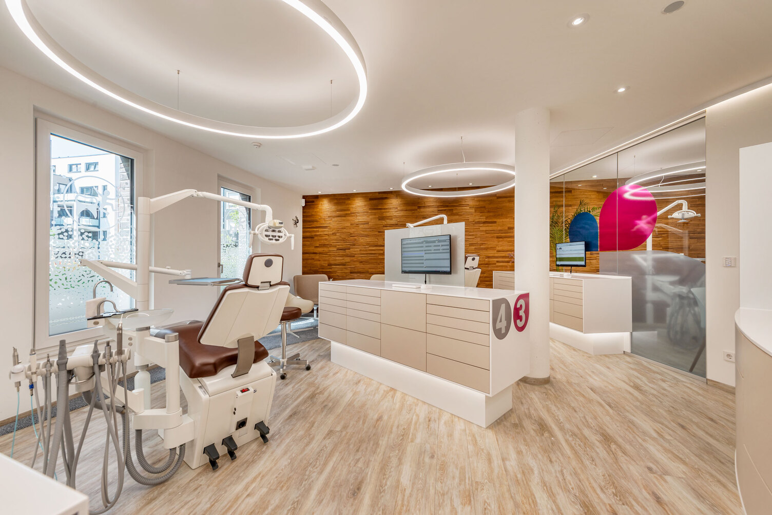 DUETTO MED ring light in the dental practice of Dr Grammatidis Dental practice Dr Grammatidis with several treatment chairs above which a ring light is suspended, pleasant atmosphere also due to the brown structured wooden wall.