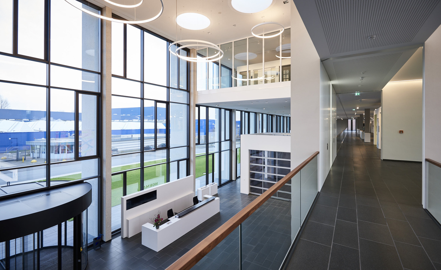 Blick auf die SATTLER CIRCOLO in einer Lobby auf Stockwerkshöhe Blick auf die Leuchten CIRCOLO der Firma SATTLER in verschiedenen Durchmessern, von einem Stockwerk aus in Richtung Empfang fotografiert