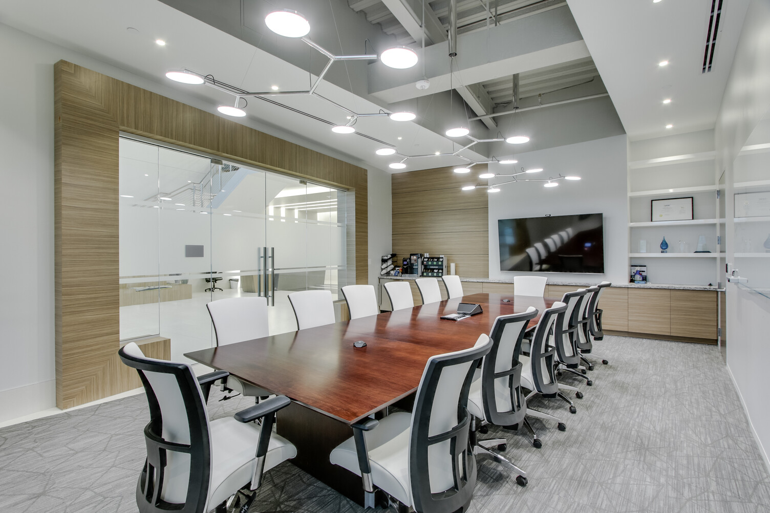 SATTLER AVVENI Pendant 6 Type 1 in polished aluminium over conference table photographed further away Three AVVENI Pendant 6 Type 1 in polished aluminium were photographed from a different angle in an elegant and modern meeting room for up to 14 people