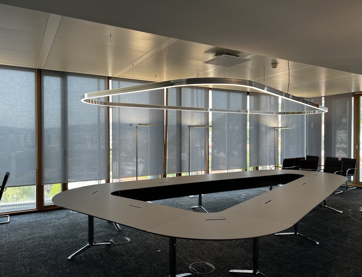Customised Lighting Solutions - DUETTO in a delta shape - above conference table Delta-shaped conference table in the LBBW Stuttgart with customised DUETTO ring light, perfectly adapted to the delta shape of the table