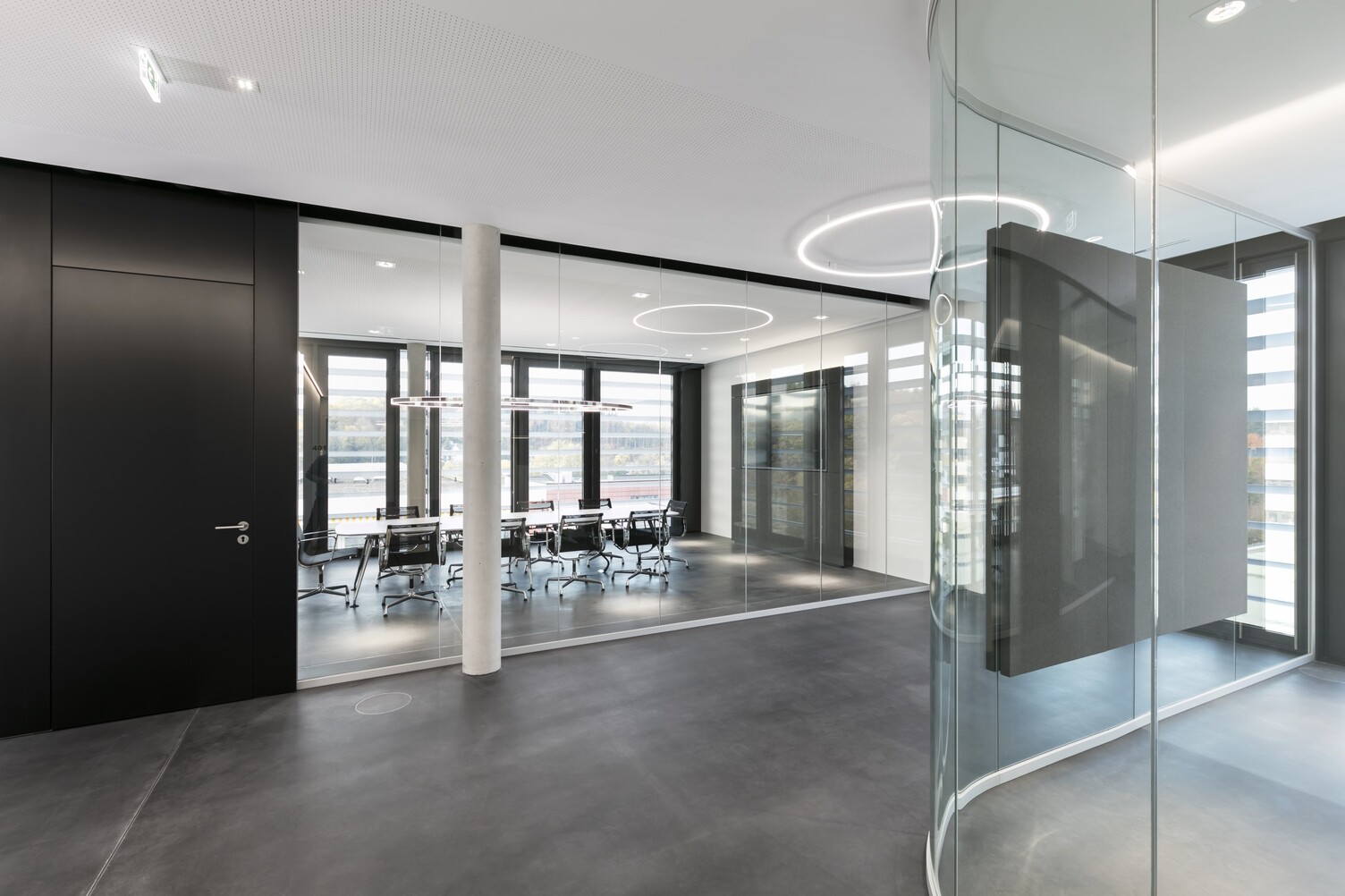 Slim direct from SATTLER mounted directly on the ceiling in a corridor | © SATTLER | Nikolay Kazakov niko design corridor area with a Slim arranged directly. In the glass office behind, a Doppio Ellipse was suspended above a meeting table. | © SATTLER | Nikolay Kazakov niko design