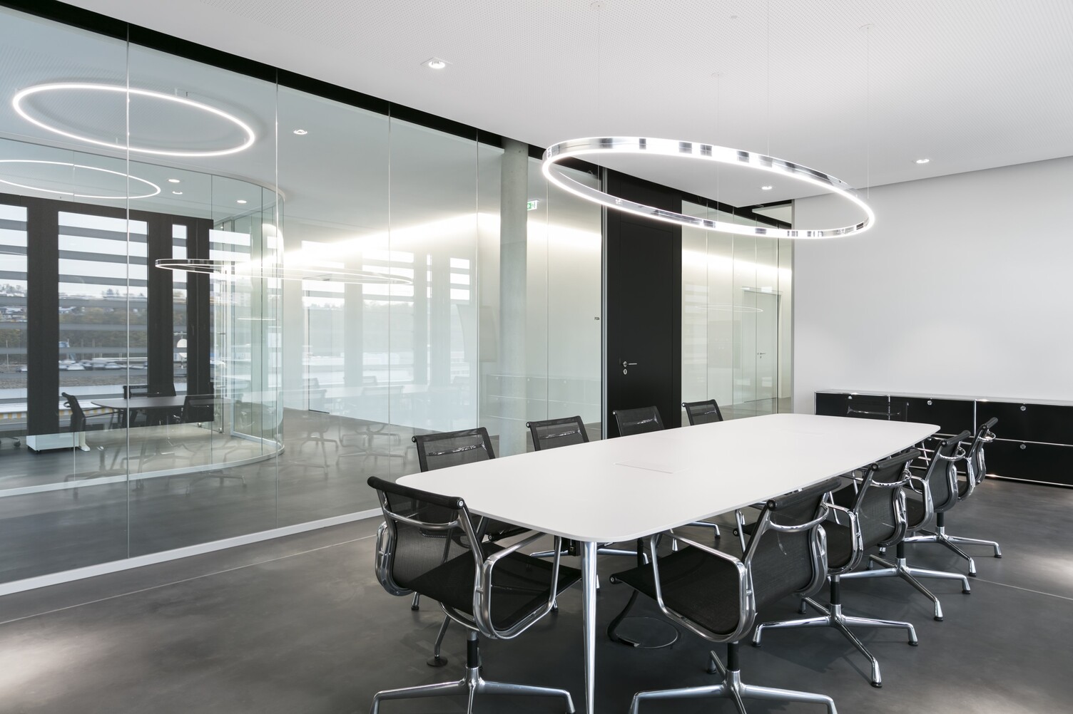 Doppio Ellipse with BE2 spotlights, each by SATTLER, arranged in a glass meeting room above a white table in a wider perspective | © SATTLER | Nikolay Kazakov niko design Doppio Ellipse with BE2 spotlights, each by SATTLER, arranged in a glass meeting room above a white table in a wider perspective | © SATTLER | Nikolay Kazakov niko design