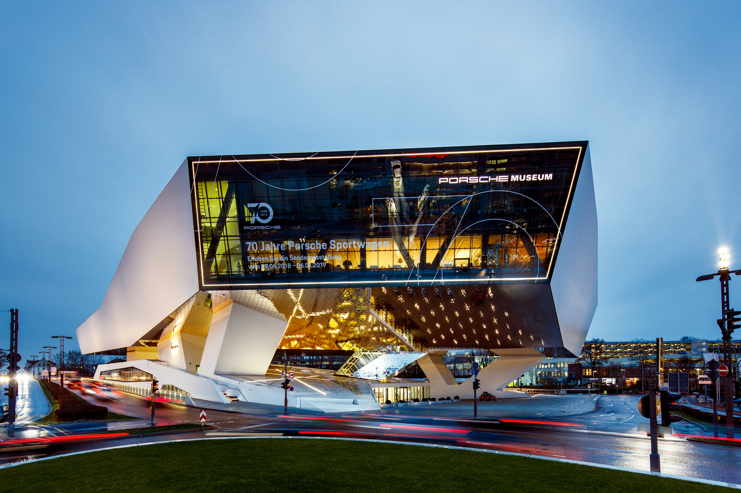 Full view of the Porsche Museum building in Stuttgart with dynamic evening lighting by Sattler.