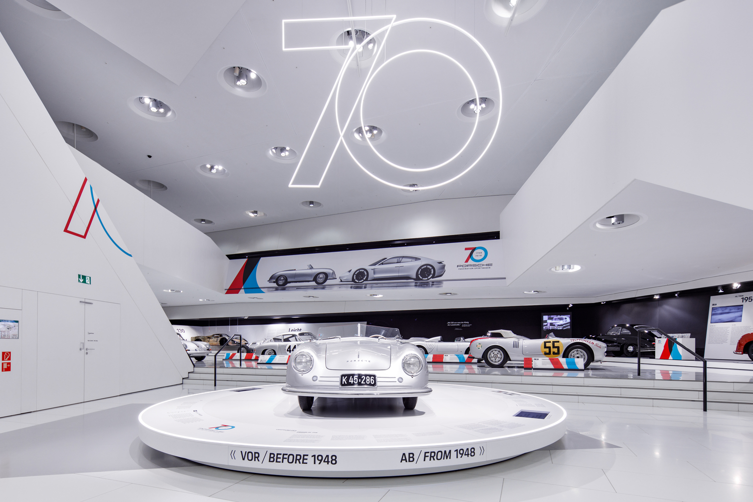 Interior view of the Porsche Museum in Stuttgart with the Paris-Dakar exhibition and modern lighting by Sattler for the 70th anniversary of Porsche sports cars. For the windows, an illuminated frame was planned, developed and installed as an illuminated picture frame with our CoveLighting in a special design. Photographed here in a different view.