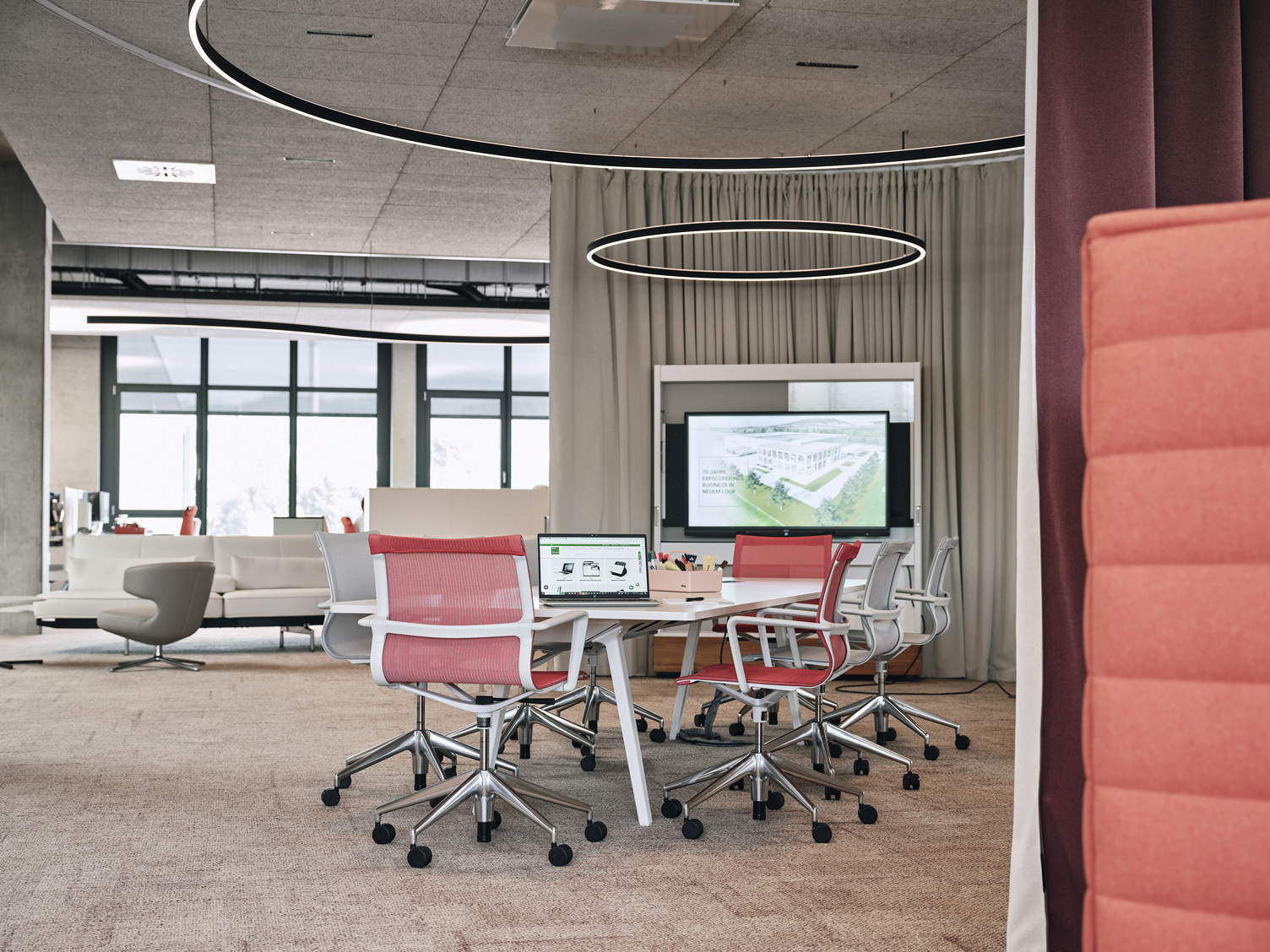 Streit Meeting Area - Featuring Doppio by Sattler Round meeting area at Streit, featuring a central seating arrangement and Sattler's Doppio lighting fixture with direct and indirect light emission. In the background is a curved Duetto special luminaire, also with direct indirect light.