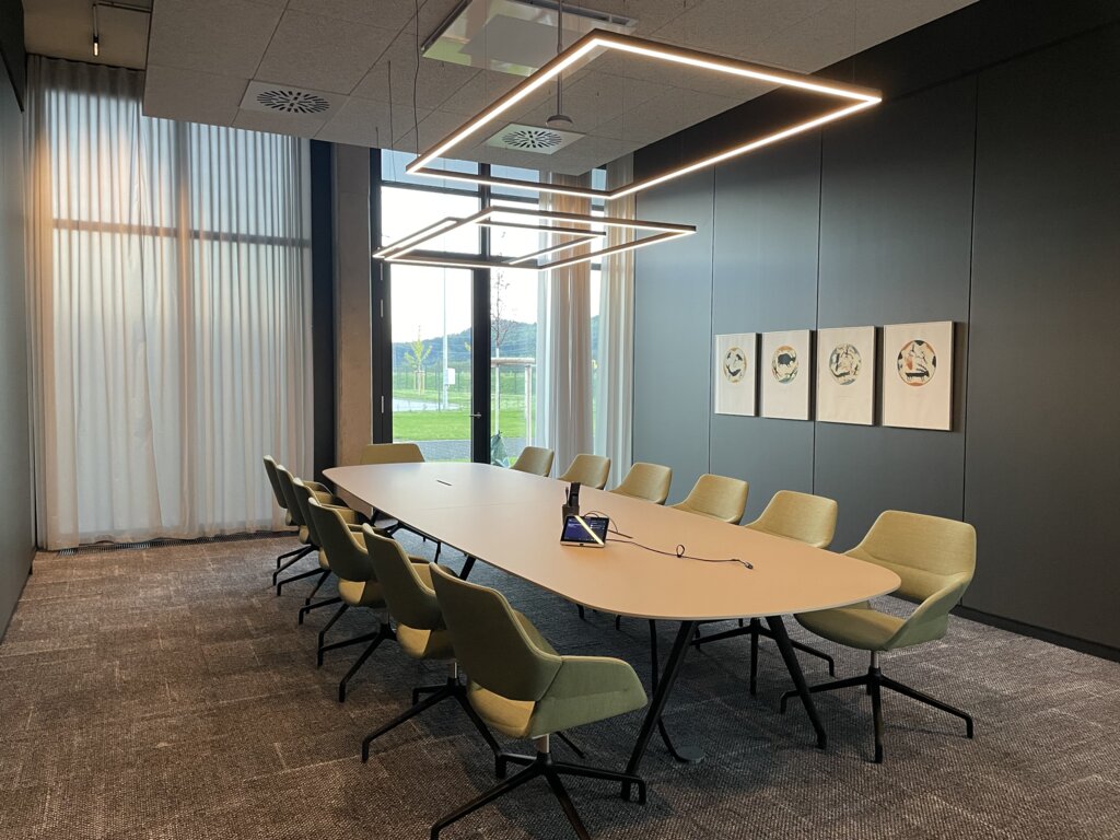 Modern meeting room at Streit with large windows and Sattler's Gioco Direct lighting fixture. | © Kuehnmedia