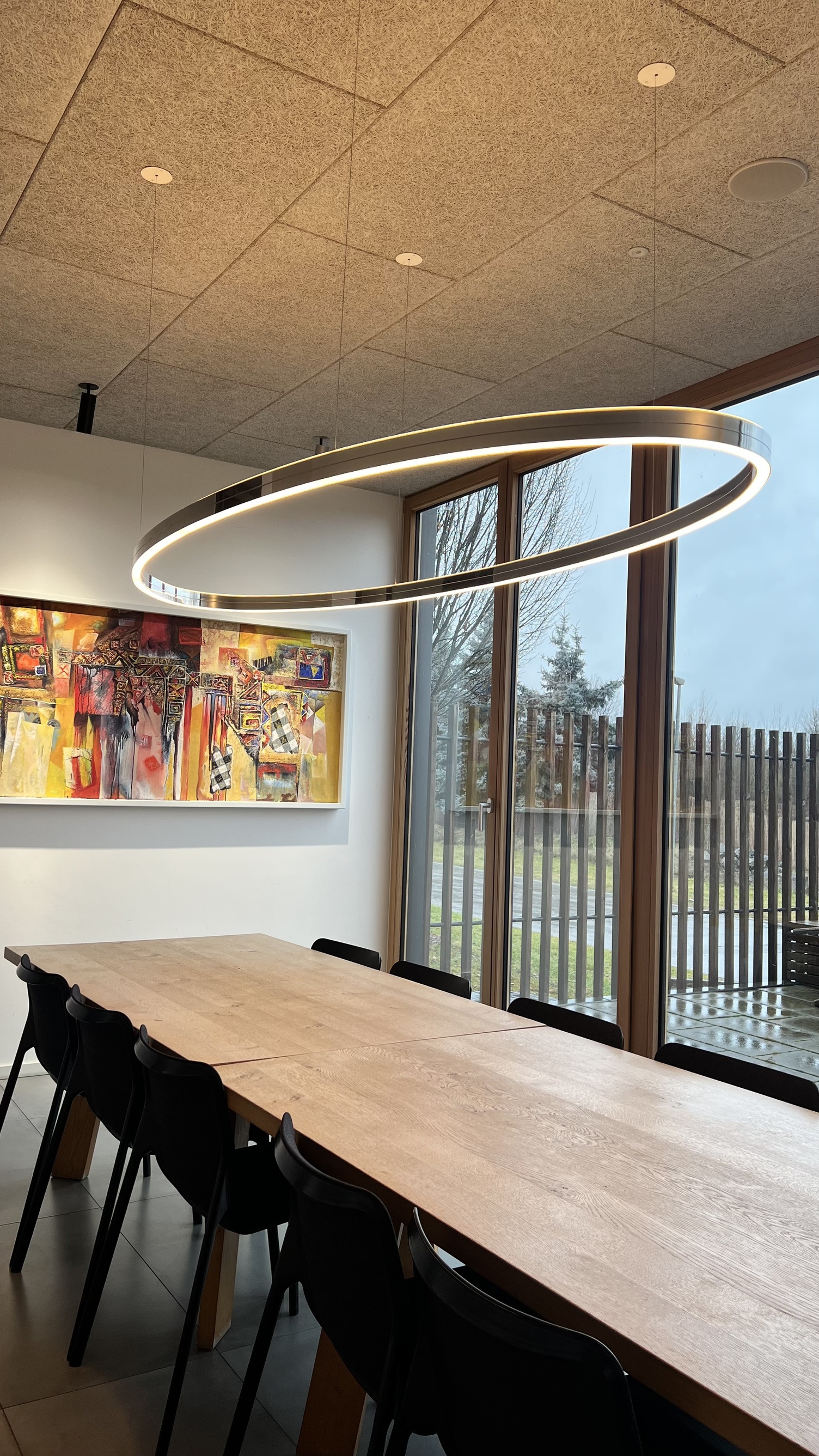 SLIM ELLIPSE LED Ring Light above Kitchen Table – Filigree Pendant for Modern Living Spaces Filigree SLIM ELLIPSE LED ring pendant by SATTLER above an elegantly set kitchen table, elliptical ring light providing direct illumination in a modern residential interior.